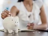 Woman putting money in a piggy bank